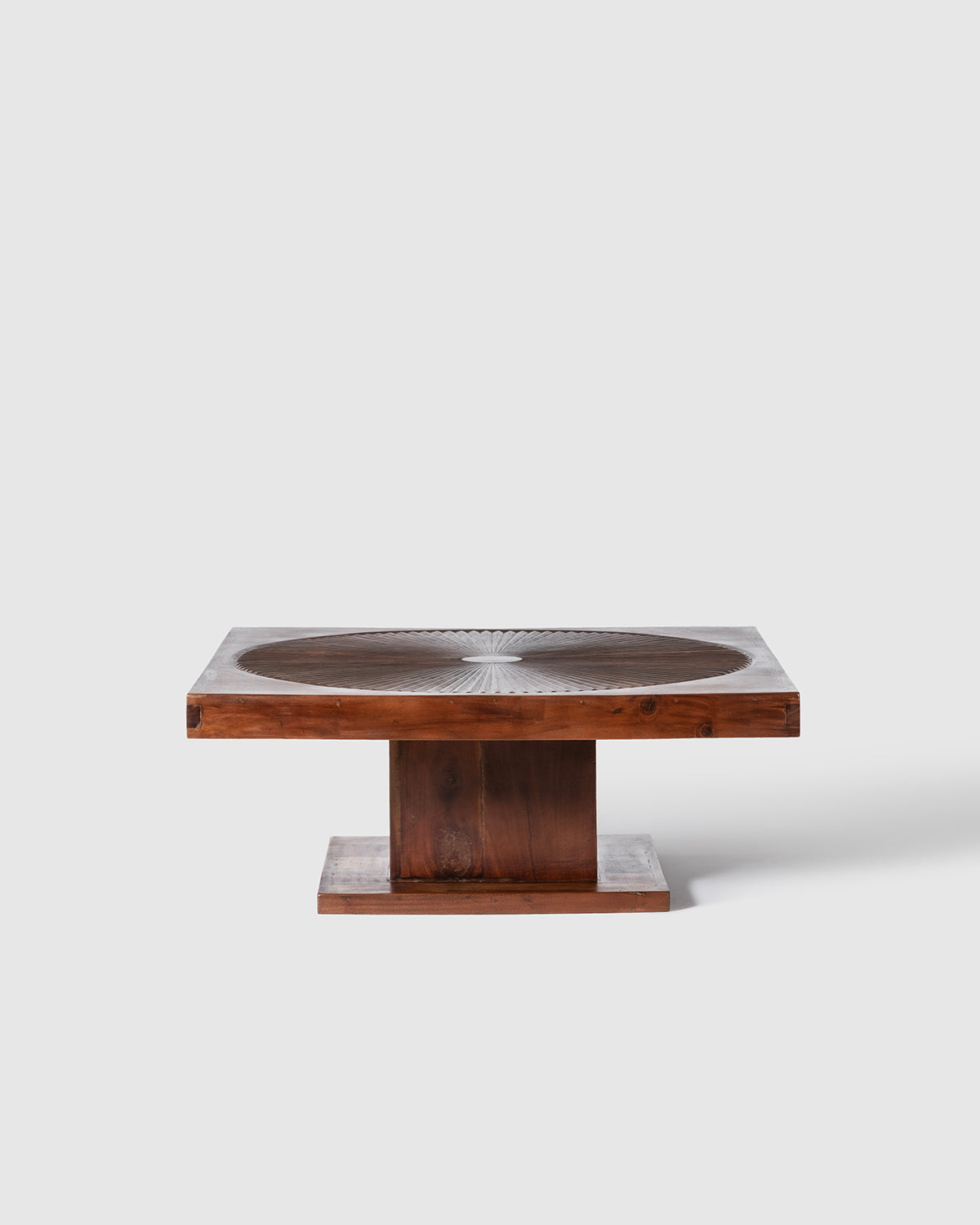 A modern square wooden coffee table with a dark brown wood grain finish, featuring a circular inset on the tabletop and a solid block base