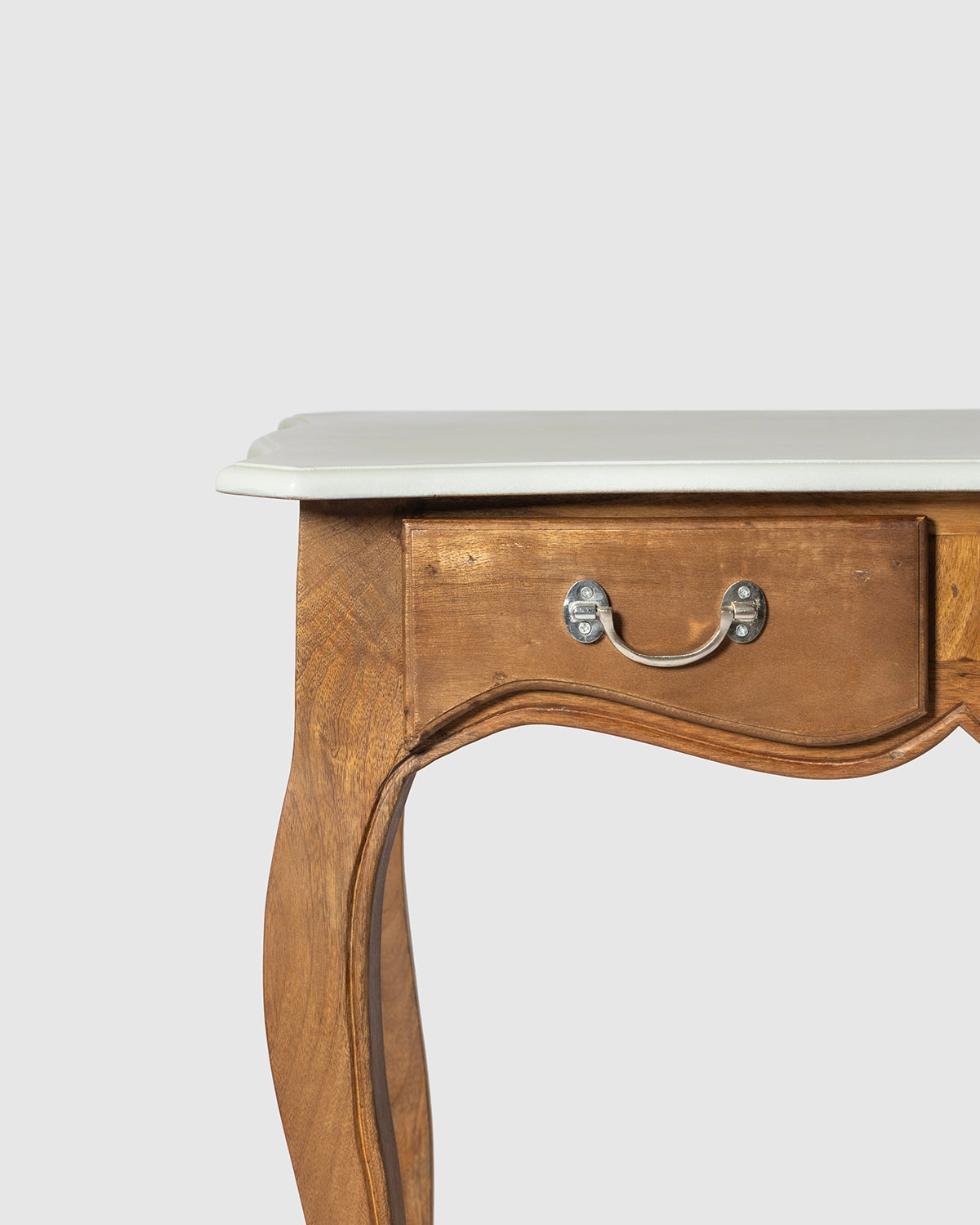 Close-up of a wooden writing desk featuring a colonial finish, a single drawer with a silver metal pull, and a gray top