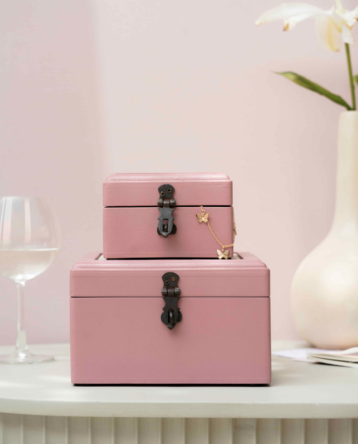 Two stacked pink wooden storage boxes with black metal latches