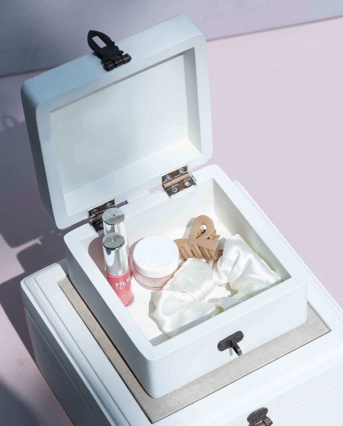 A white wooden cosmetic storage box with an open lid, to keep skincare and beauty items inside