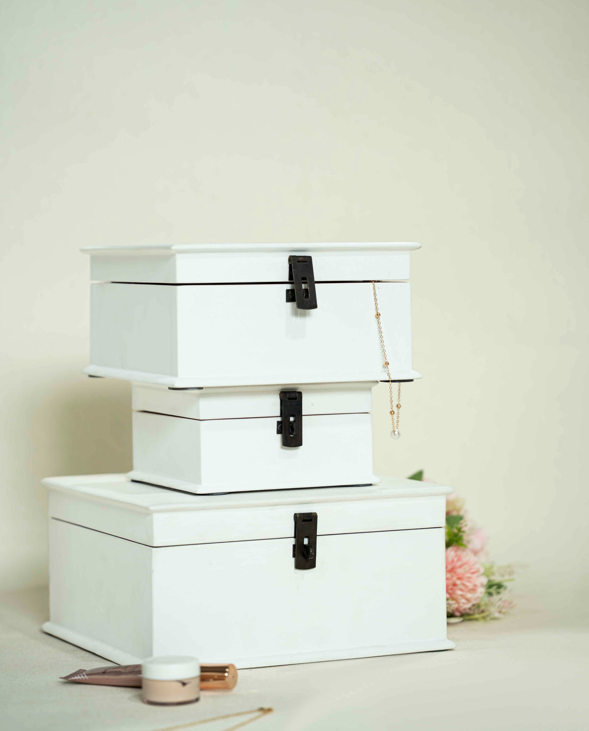 Three stacked white wooden storage boxes or decorative boxes with black metal clasps