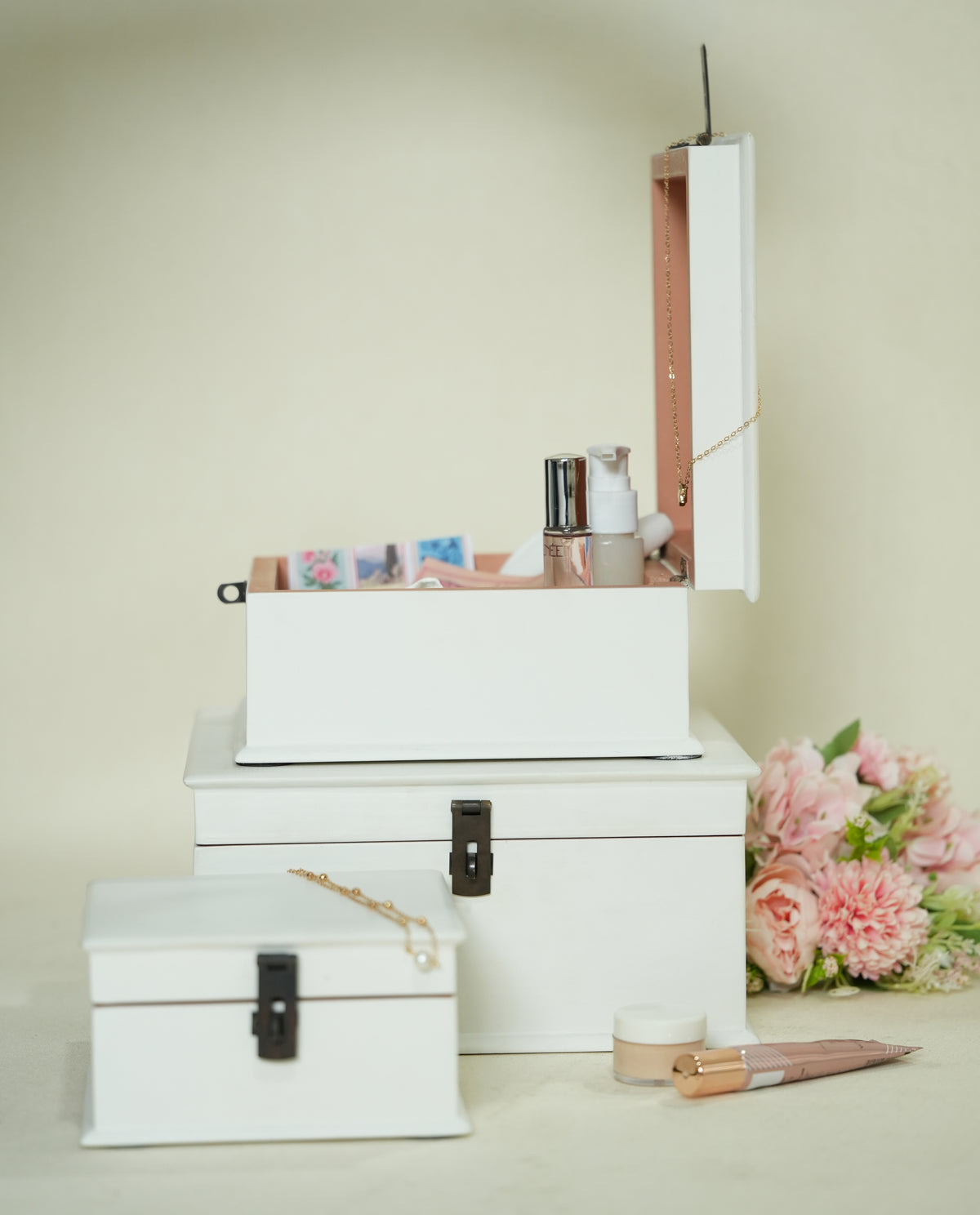 Three stacked white cosmetic storage boxes with black clasps