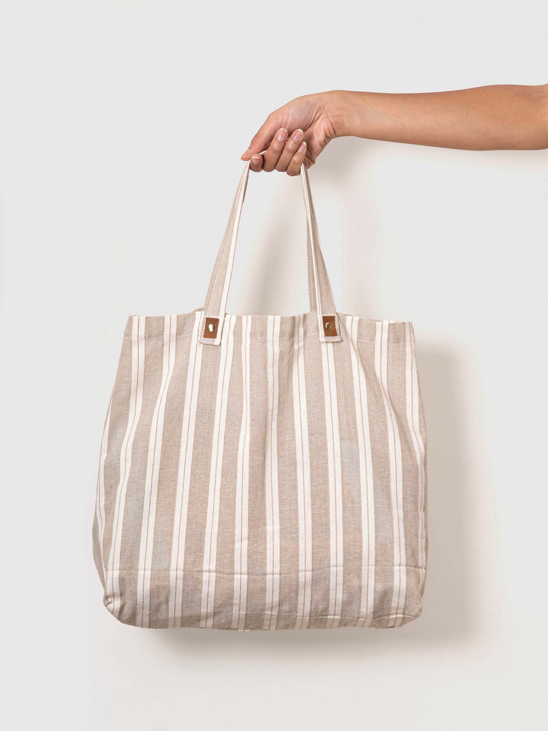 Person holding a striped tote bag