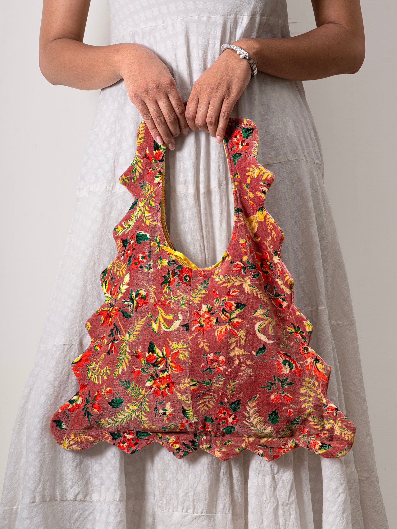 Person with a floral-patterned velvet floral tote bag
