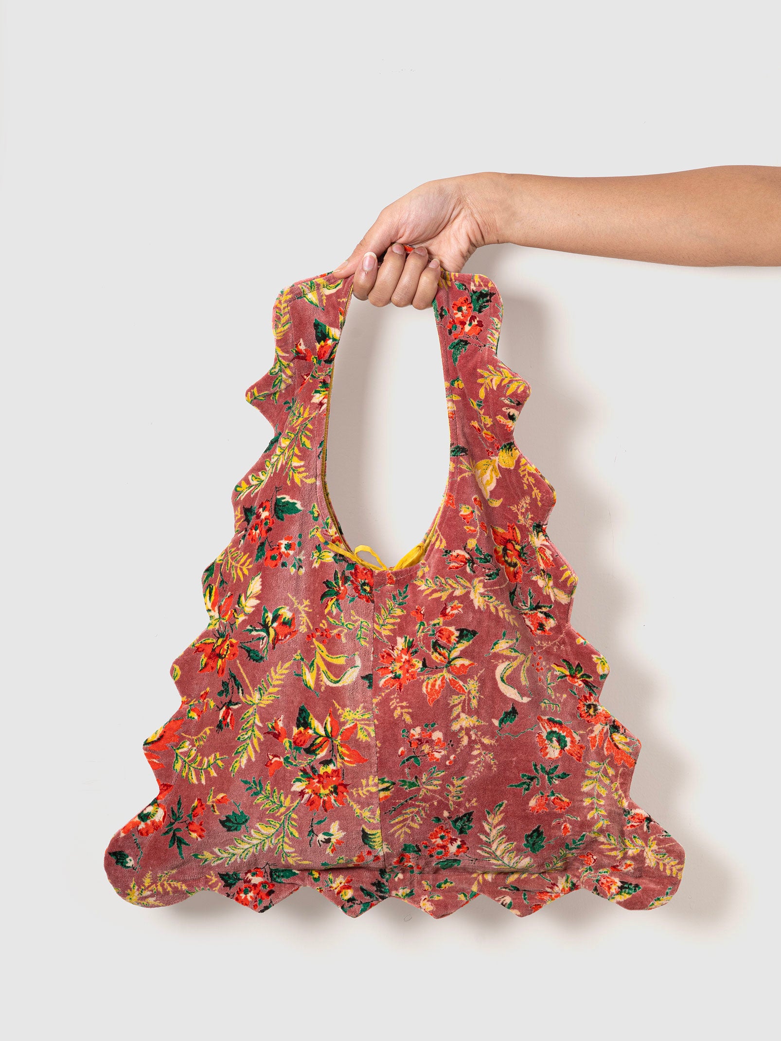 Floral-patterned velvet tote bag held by a person