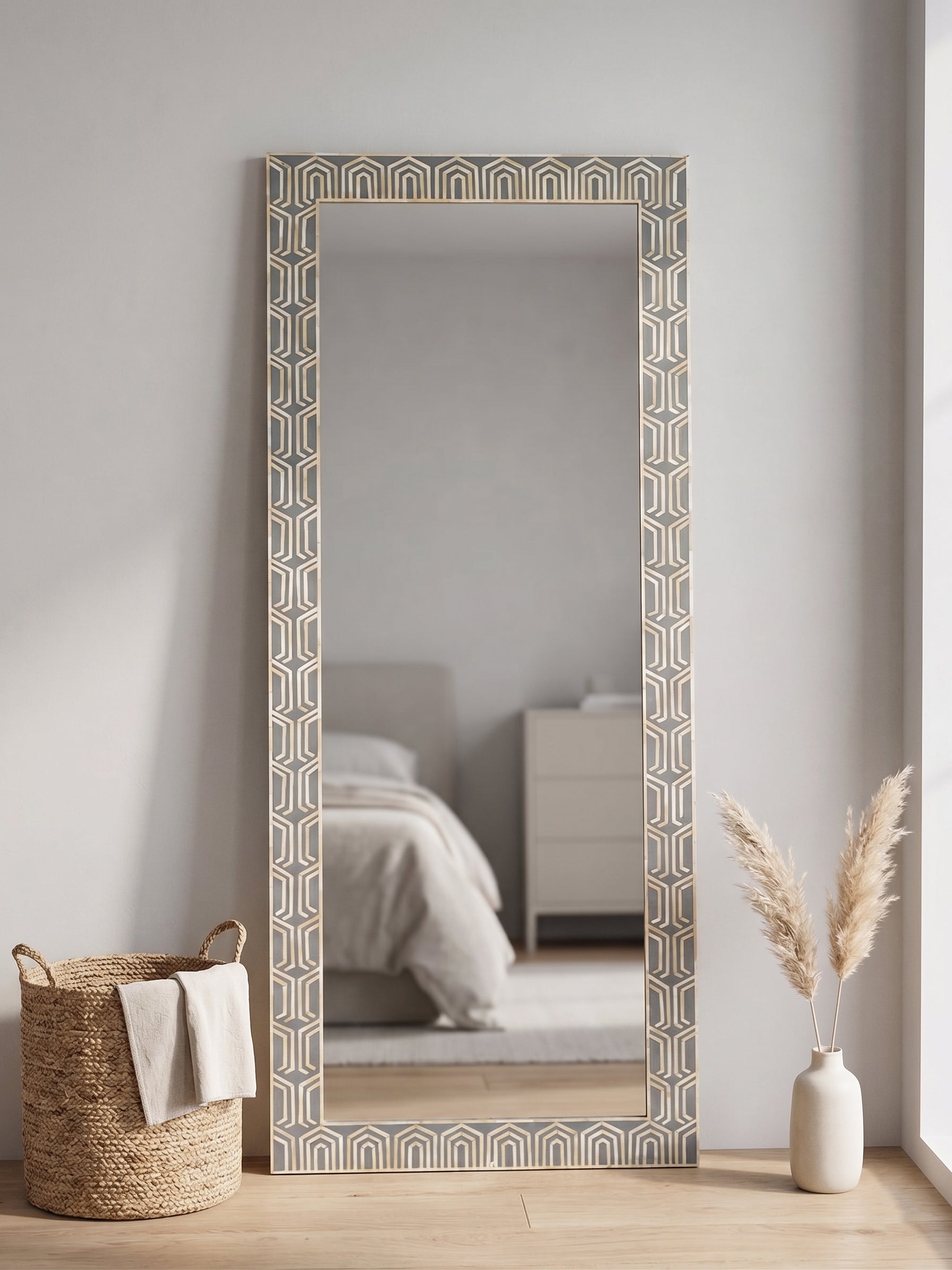 Decorative full-length mirror with geometric pattern in a living room setting.