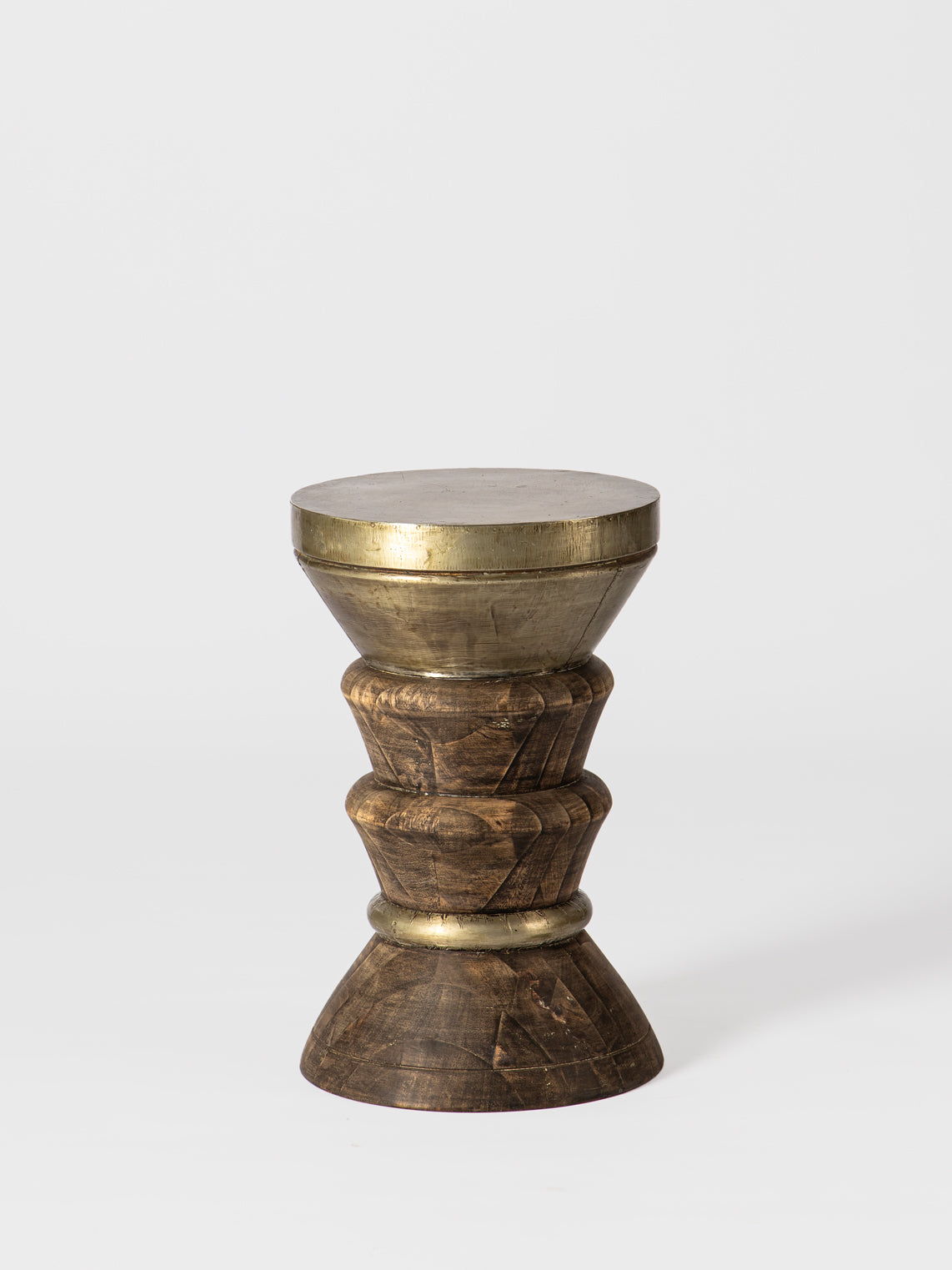 Decorative stool with brass top and wooden base on a white background
