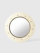 Round mirror with a beige frame on a light gray background