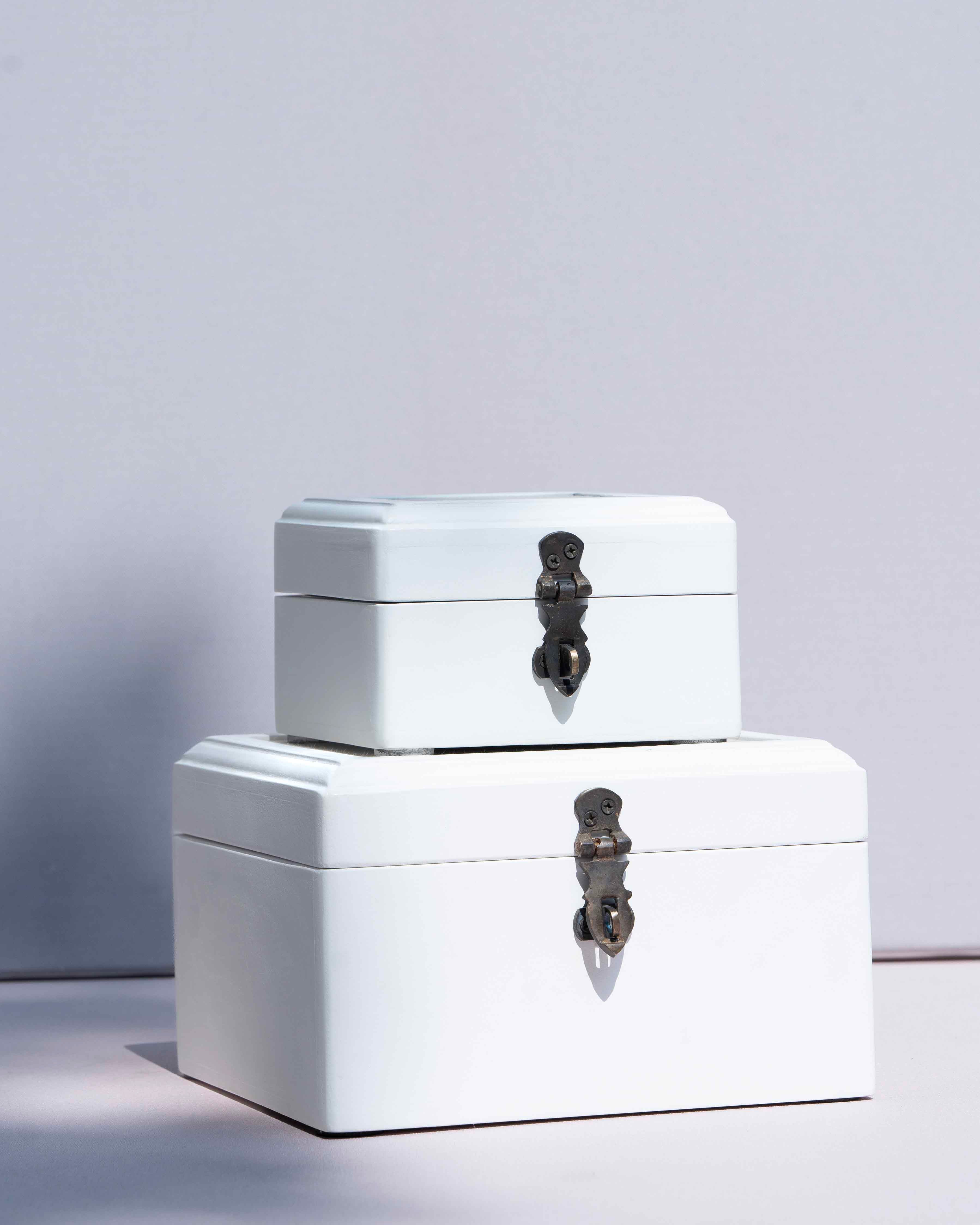 Two stacked white storage boxes with dark metal clasp lids