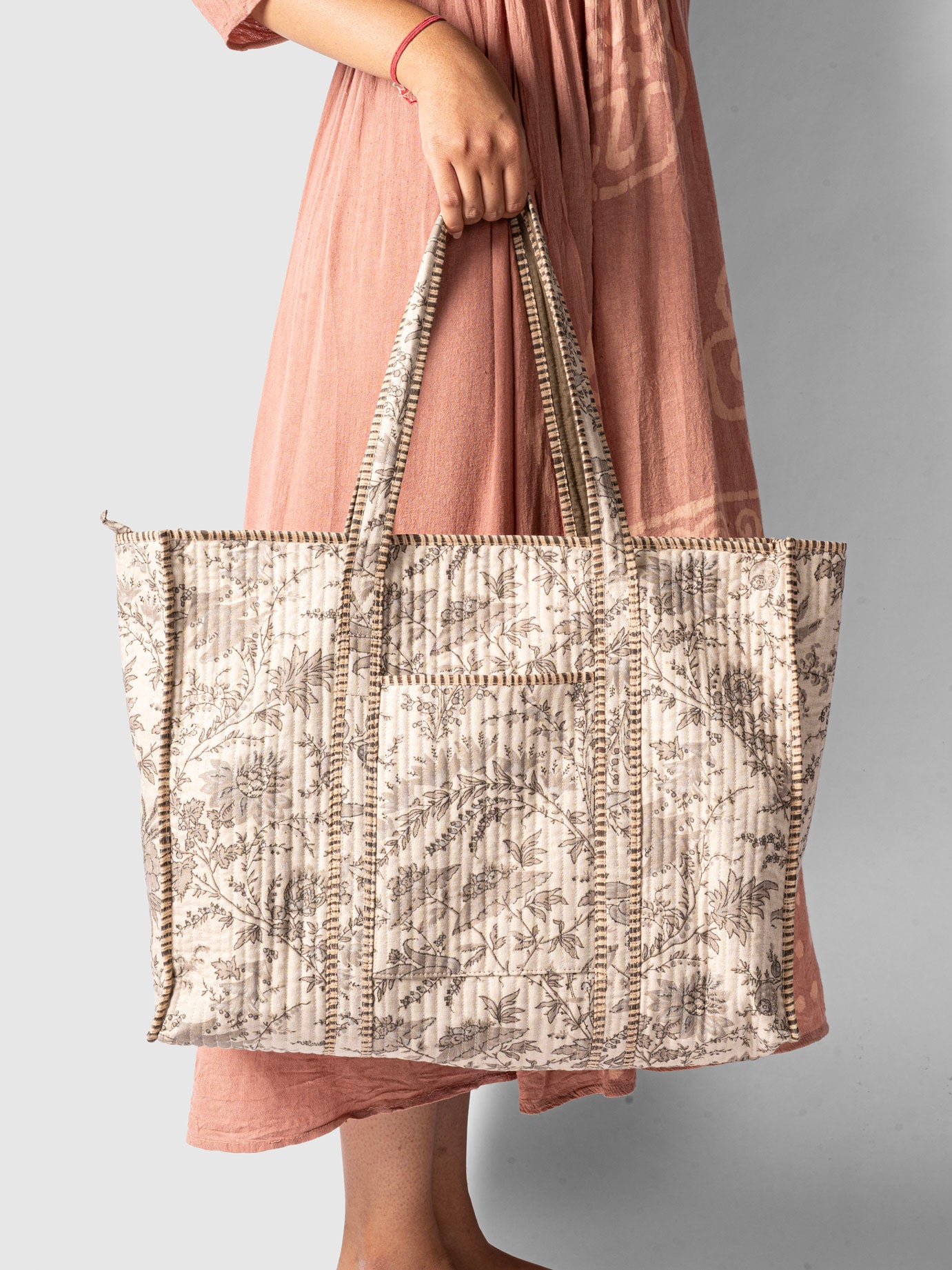 Person holding a patterned tote bag 
