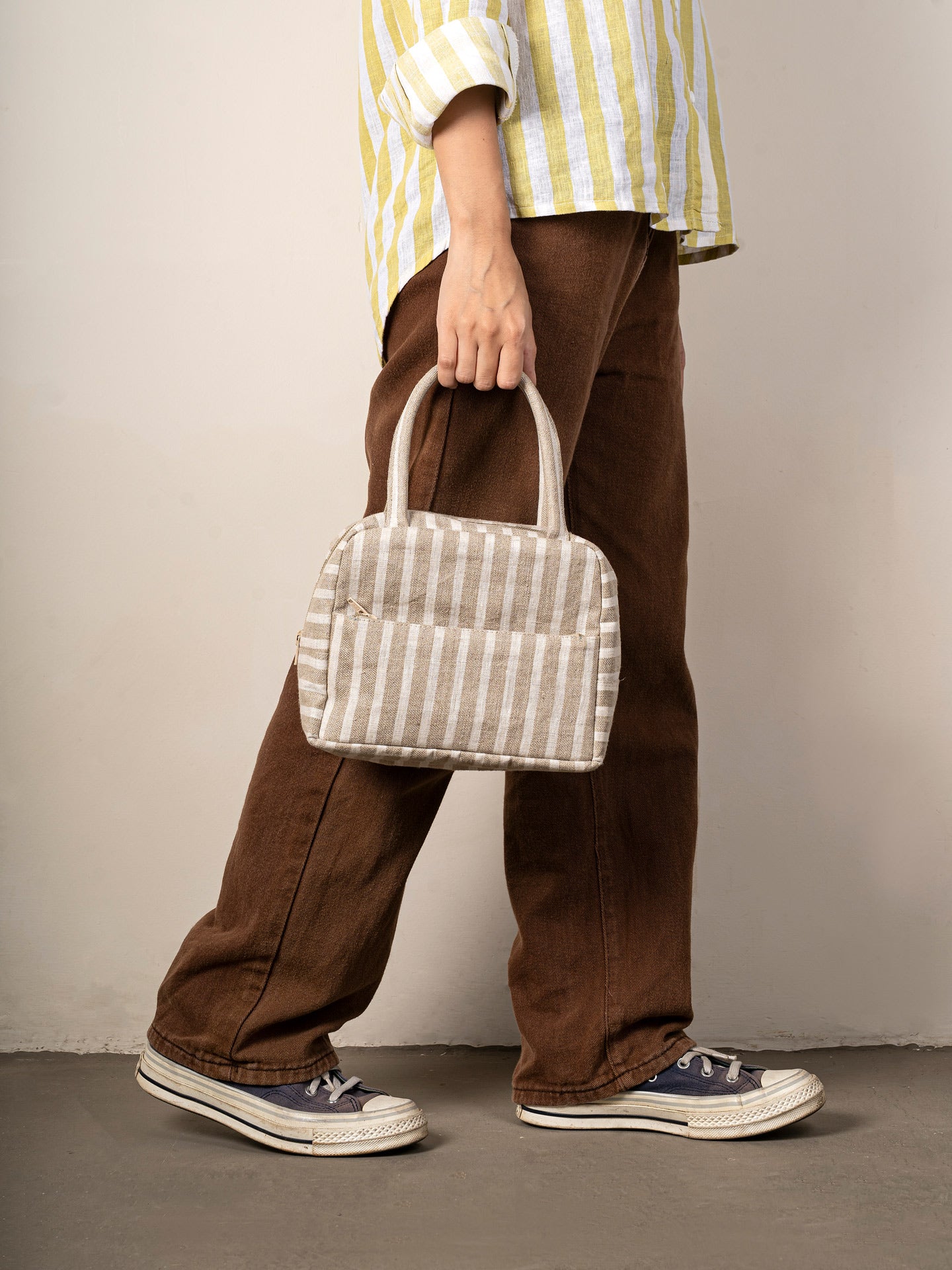 Girl holding a striped handbag
